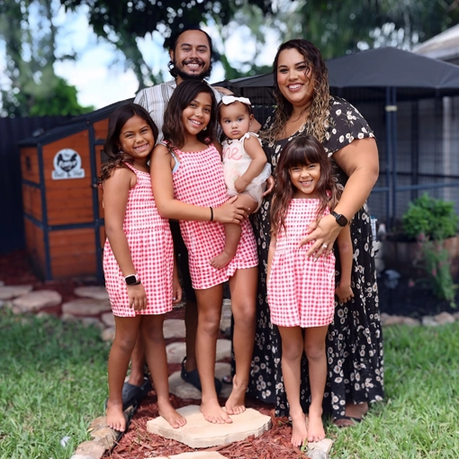 Alfonso Chie smiling with his four daughters and wife.